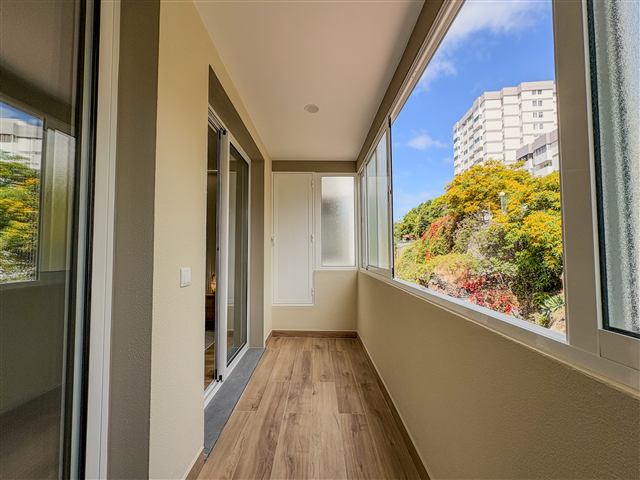 Varanda envidraçada com vista para jardim